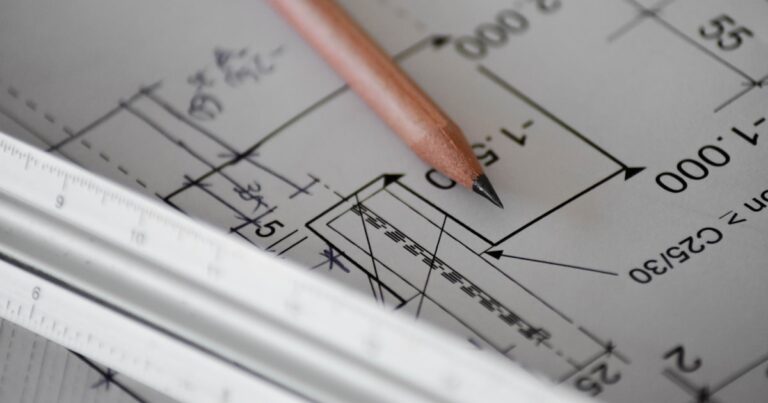 A pencil resting on architectural blueprints