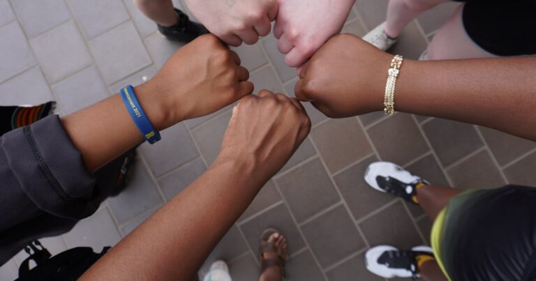 A group of people putting their hands together